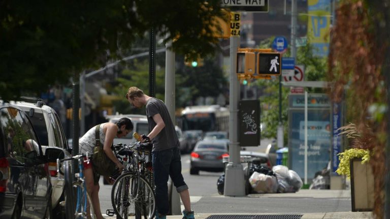 Friends lock up their bikes before heading off in Clinton Hill. (August 10, 2013)