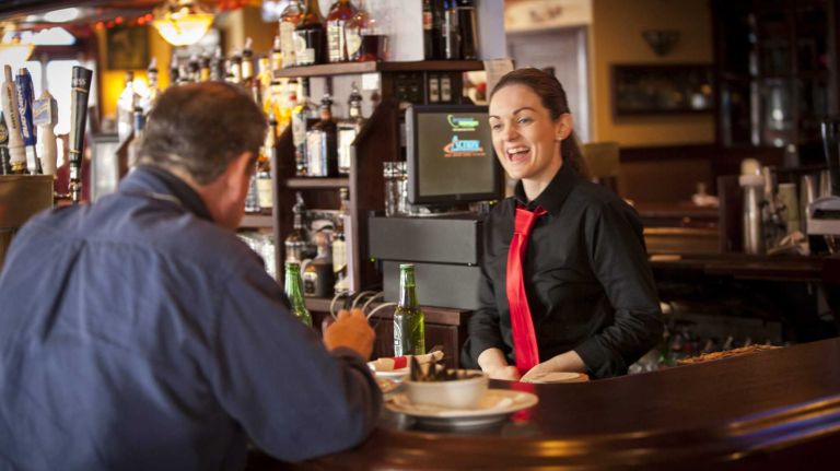 Sharon Loughnane laughs with a customer at the Rambling House Bar on Katonah Ave. in Woodlawn.