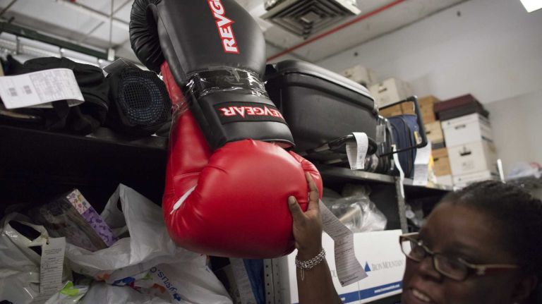 Melissa Gissentanner, the manager at the MTA's Metro-North Railroad Lost & Found in Grand Central Terminal, shows an unclaimed pair of giant-sized boxing gloves on August 28, 2013.