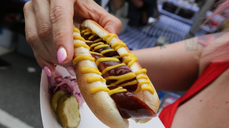 Holly Holbrook-Gross has a kielbasa from the J&E Small Goods booth.