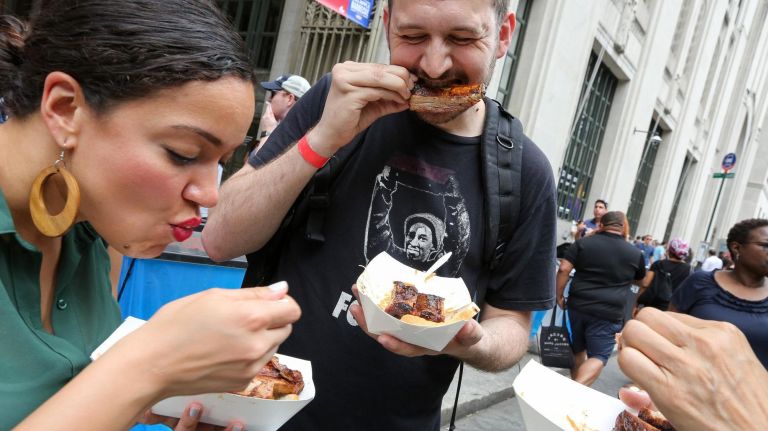 Tiffany Charbonier, left, and Matt Huiatt eat ribs from Rodney Scott's BBQ.