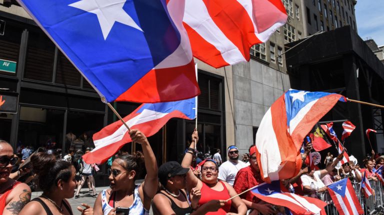 Spectators wave flags during the Puerto Rican Day Parade on Sunday, June 11, 2017.