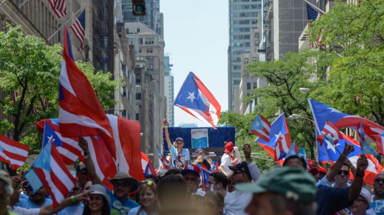 Participants hold up flags during the Puerto Rican Day Parade in Manhattan on Sunday, June 11, 2017. 