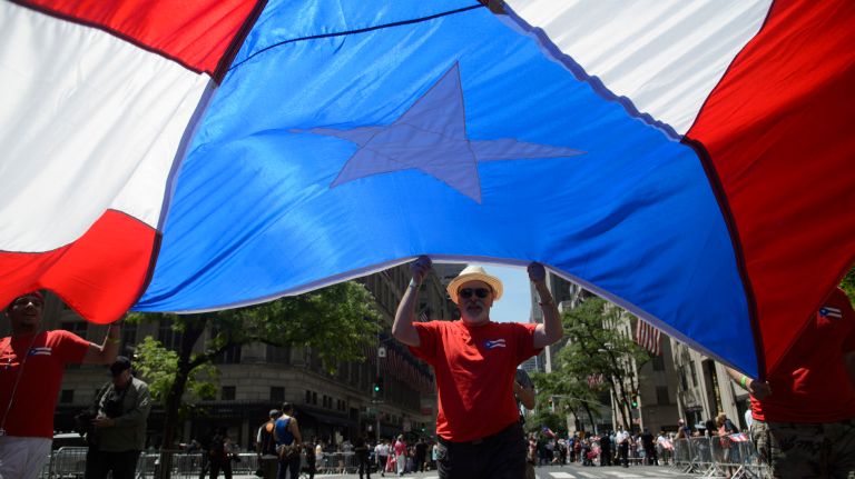 Participants wave an oversized Puerto Rican flag during the 60th annual Puerto Rican Day Parade on Sunday, June 11, 2017.