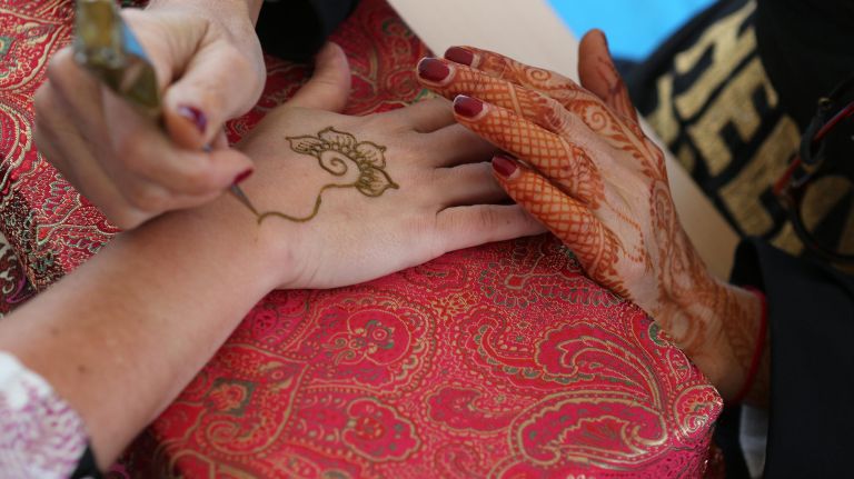A partier has her hands hennaed.