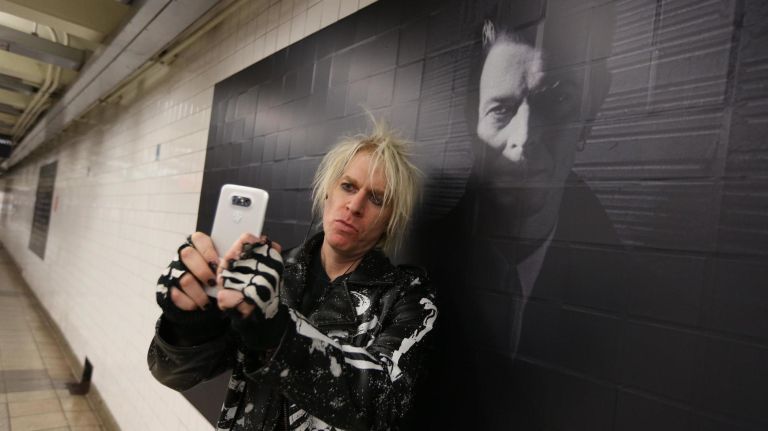 Jonny Red, from Boston, stops to take a selfie at the David Bowie exhibit inside the Broadway-Lafayette Street subway station.