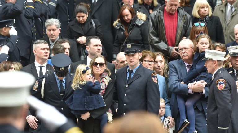 Eileen Davidson, wife of fallen firefighter Michael Davidson, and other family members leave the church following the service at St. Patrick's Cathedral on Tuesday.