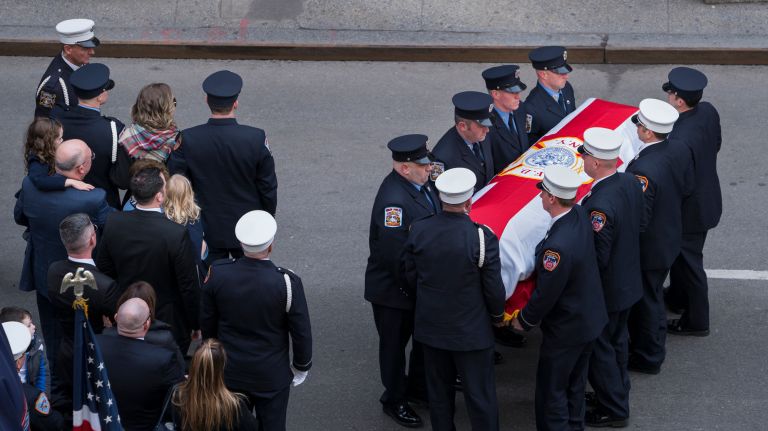 The casket carrying FDNY firefighter Michael Davidson, who was killed in the line of duty while battling a Harlem blaze, is walked into St. Patrick's Cathedral on Tuesday.