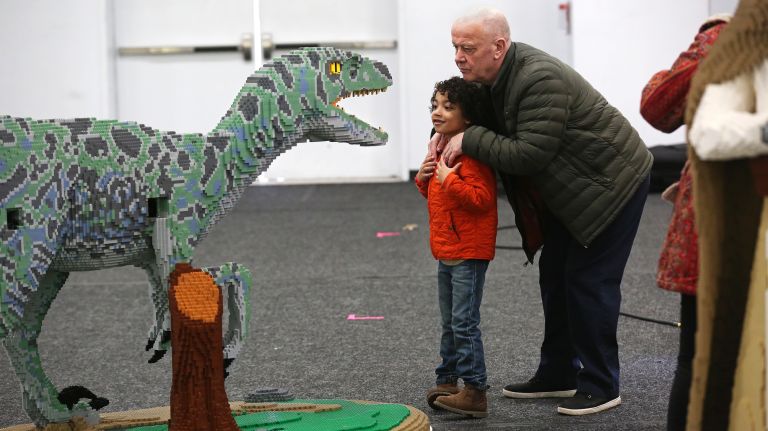 James Hind, 5, and his dad, David Hind, both of Mineola, get a sneak peak of a Lego velociraptor made from 25,000 Lego blocks at the Lego Live NYC display at Pier 36 on Manhattan on Feb. 14, 2018.