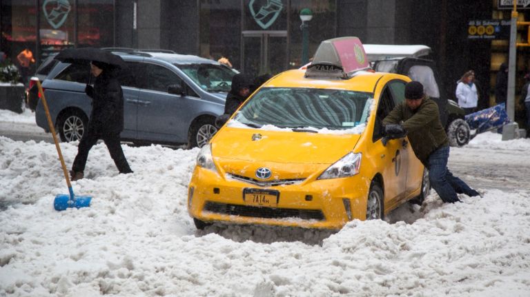 Snow in NYC: Photos from winter 2016-2017 39 A man helps a taxi go through a pile of snow near Broadway and 49th Street in Manhattan on Tuesday, March 14, 2017.