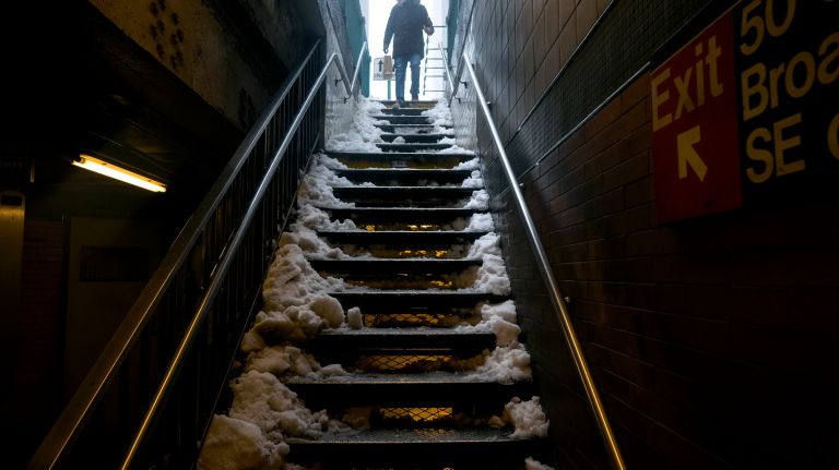 A pedestrian cautiously walks down snowy stairs to the 1 train at 50th Street in Manhattan on Tuesday, March 14, 2017, during a snowstorm.