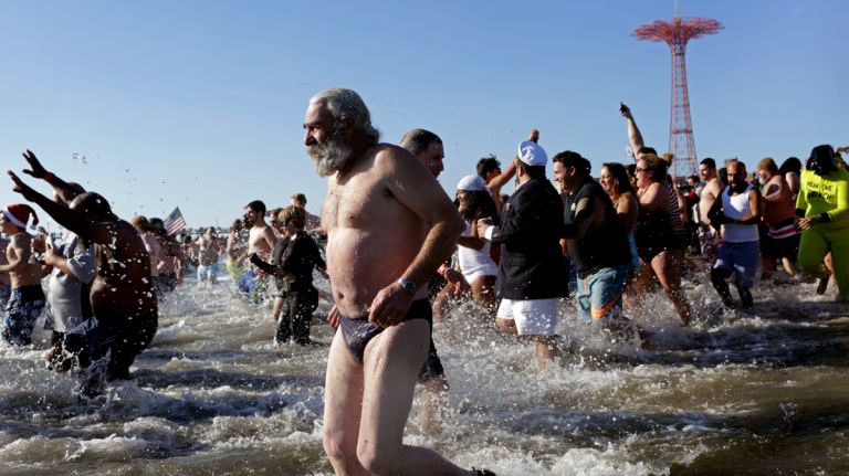 Swimmers run into the cold, cold ocean during the Coney Island Polar Bear Club's New Year's Day Plunge on Jan. 1, 2017.