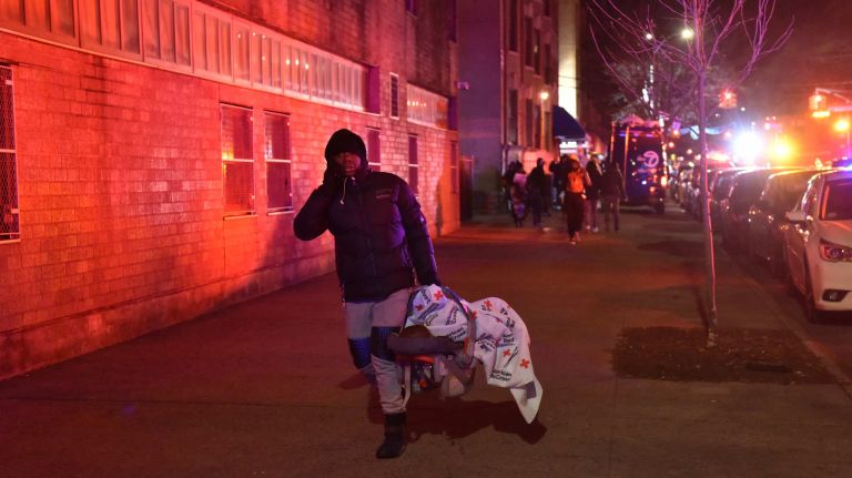 Fire in Belmont, Bronx: Photos from the scene 10 A person walks from the scene of the fire in the Belmont neighborhood of the Bronx that killed 12 and injured others on Thursday, Dec. 28, 2017.