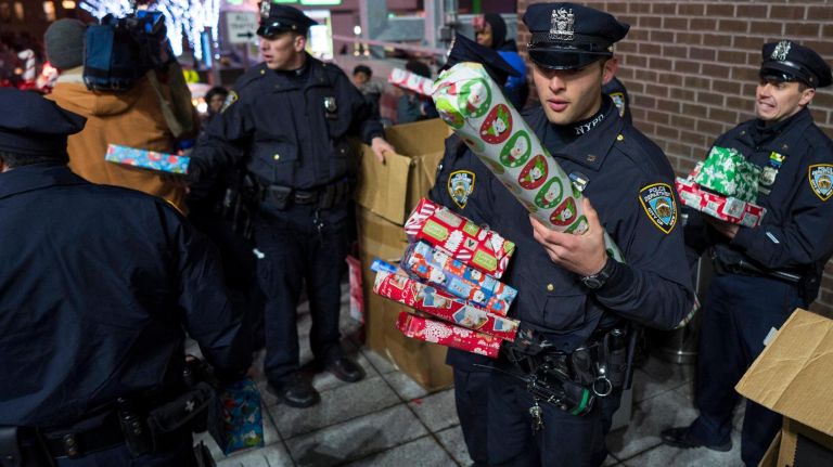 NYPD officers in the 79th precinct hand out gifts to children, Dec. 21, 2017, part of the Brooklyn North's second annual Sleigh Ride.