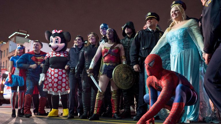 NYPD officers dressed as Spider-Man, Wonder Woman and more stop for kids on Dec. 21, 2017.