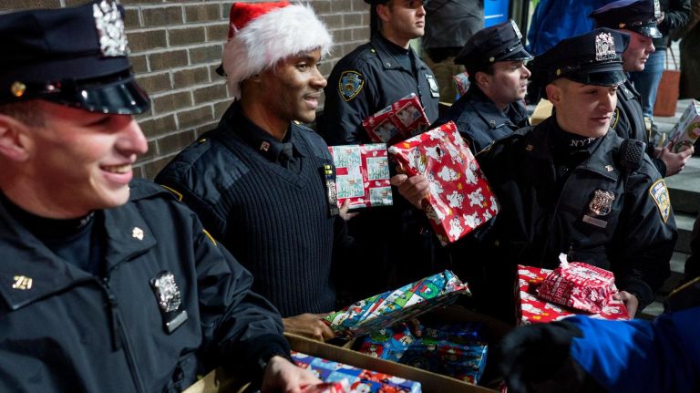 NYPD officers in the 79th precinct hand out gifts to children on Dec. 21, 2017.