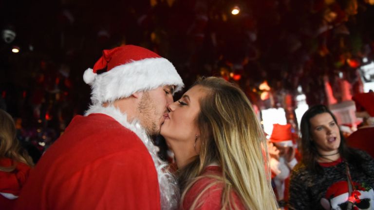 A Mr. and Ms. Claus kiss during SantaCon on Saturday, Dec. 9, 2017.