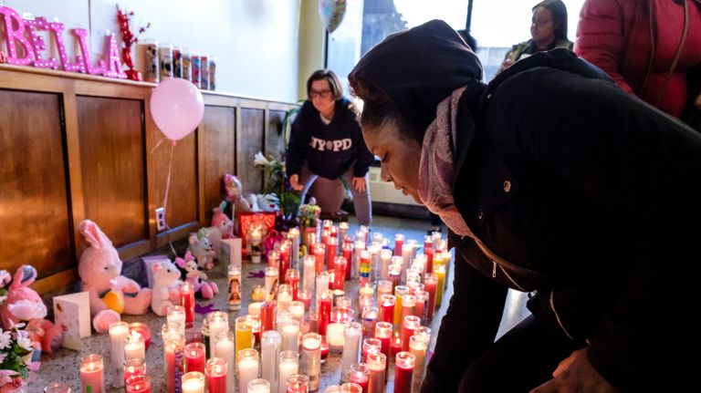 Mourners place candles, balloons and stuffed animals at a makeshift memorial during a vigil for 3-year-old Bella Edwards at her Seaside building on Wednesday, April 4.