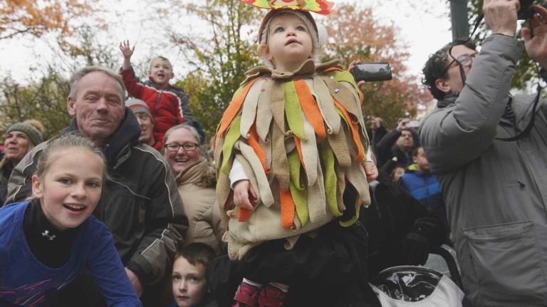 Spectators, with one in a special Thanksgiving getup, watch Santa's sleigh pass on Thursday, November 24, 2016, bringing up the rear of the 90th annual Macy's Thanksgiving Day Parade in Manhattan.