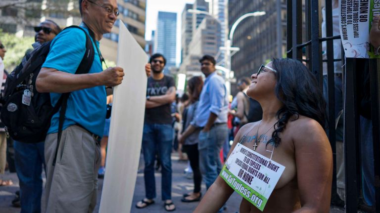 A participant rests at the end of the GoTopless Pride Parade on Sunday, Aug. 28, 2016, in Manhattan.
