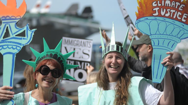 Two women dressed as Lady Liberty stand with protesters across the street from the Intrepid Sea, Air & Space Museum in Manhattan, where President Donald Trump was expected to arrive on Thursday, May 4, 2017. 