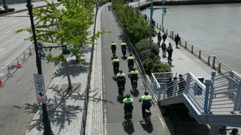 Bike-riding NYPD members patrol outside the Intrepid Air and Space Museum, before the president's visit to the decommissioned aircraft carrier on May 4, 2017.