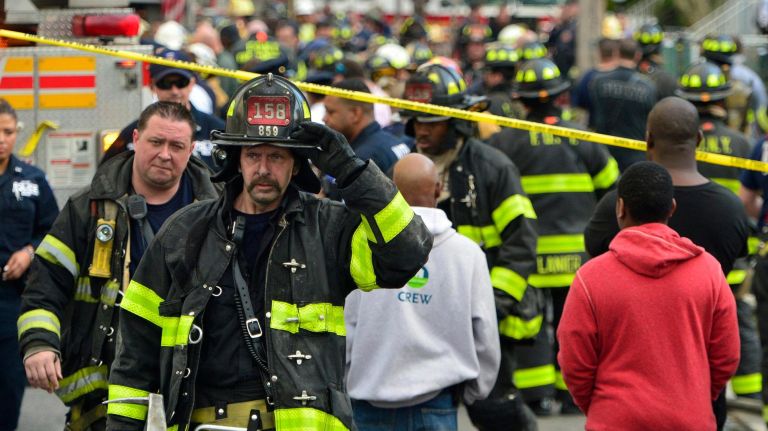 A firefighter leaves the house fire in Queens Village on Sunday, April 23, 2017.