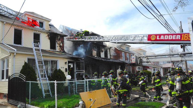 FDNY firefighters work at a house fire at 112th Avenue and 208th Street in Queens Village on Sunday, April 23, 2017. The fire, first reported at 2:36 p.m., extended to a neighboring building, FDNY officials said