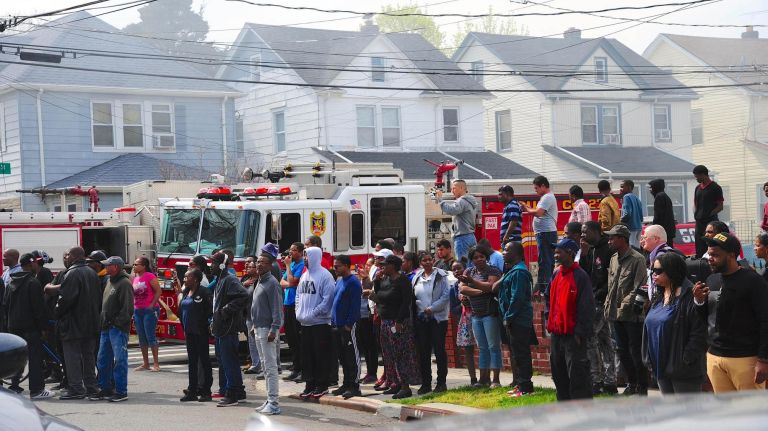 Residents observe the scene of a fatal house fire in Queens Village on Sunday, April 23, 2017.
