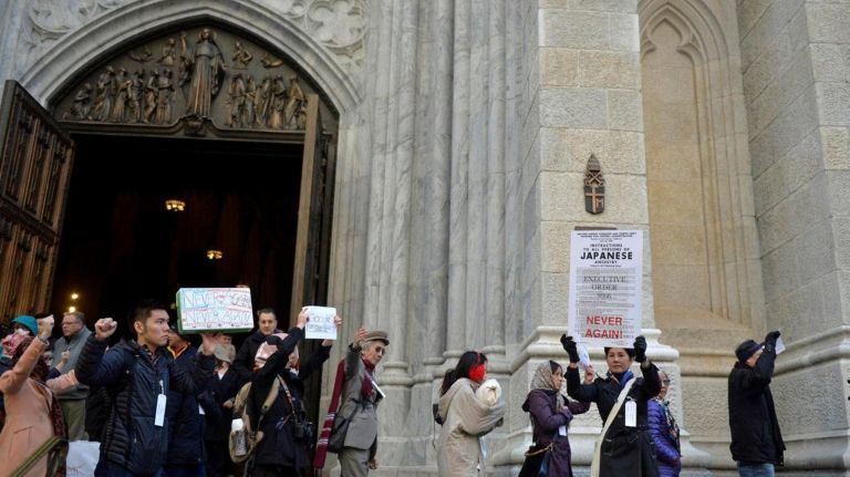 About two dozen people marched from Columbus Circle in Manhattan to the Japanese American Church on 7th Ave. on Saturday, Feb. 18, 2017 to commemorate the Japanese Americans who were held in concentration camps on U.S. soil 75 years ago after President Franklin D. Roosevelt signed executive order 9066 in 1942. Here the marchers are seen in front of St. Patrick's Cathedral. The executive order authorized the U.S. military to remove 120,000 people of Japanese descent from their homes on the west coast to inland concentration camps. Most were U.S. citizens at the time of their internment. The march commemorated the day the executive order was signed and was a show of solidarity with Muslim Americans who fear the next executive order would ban them from the U.S.