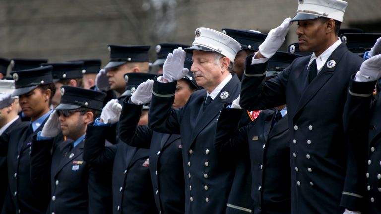Members of the FDNY salute the coffin carrying FDNY EMT Yadira Arroyo on Saturday, March 25, 2017, as it is taken inside St. Nicholas of Tolentine Roman Catholic Church on University Avenue in the Bronx. 