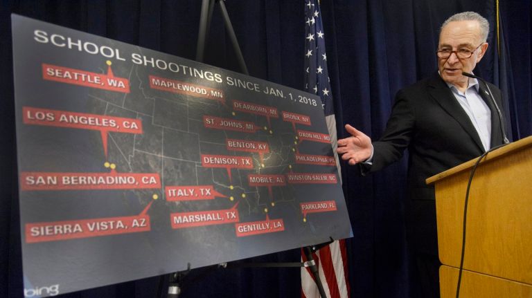   Sen. Chuck  Schumer displays a poster showing U.S. school shootings.
