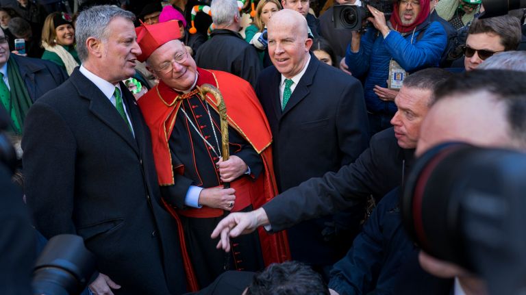Cardinal Timothy Dolan, center, stands in front of St. Patrick's Cathedral, greeting New York Mayor Bill de Blasio and New York City Police Commissioner James P. O'Neill and other participants during the New York City St. Patrick's Day parade Friday, March 17, 2017, in Manhattan.