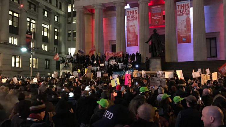 People protest Trump on the steps of Federal Hall in lower Manhattan on Jan. 20, 2017.