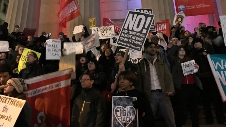 People protest Trump on the steps of Federal Hall in lower Manhattan on Jan. 20, 2017.