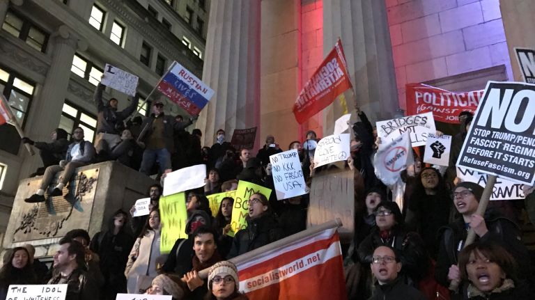 People protest Trump on the steps of Federal Hall in lower Manhattan on Jan. 20, 2017.
