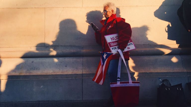 A woman checks her phone during the International Women's Strike rally in Manhattan's Washington Square Park on Wednesday, March 8, 2017.