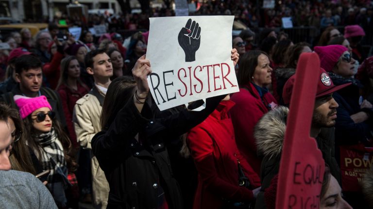 A woman holds a protest sign during the A Day Without a Woman rally in Manhattan on International Women's Day on March 8, 2017.