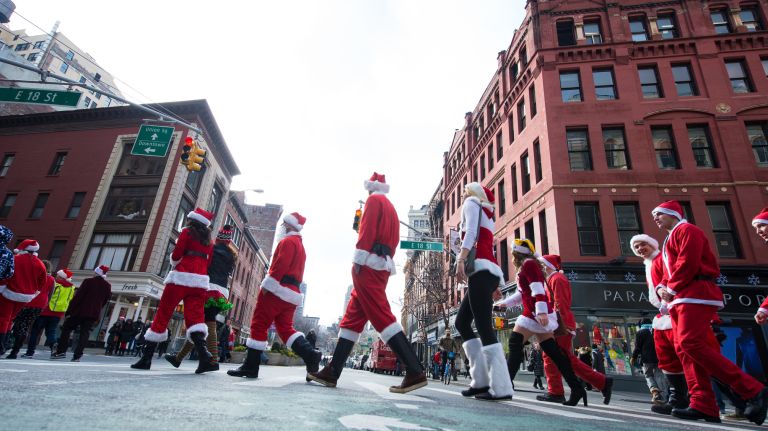 People dressed as Santas cross Broadway at 18th Street after the start SantaCon in Manhattan on Dec. 10, 2016.