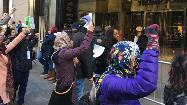 About two dozen people commemorating the 75th anniversary of the executive order that led to internment of 120,000 Japanese Americans pass silently past Trump Tower on Feb. 18, 2017. Some say they see parallels between that order and Trump's order barring entry from people from seven Muslim-majority countries.