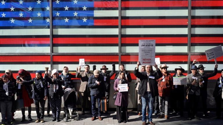 About two dozen people marched from Columbus Circle in Manhattan to the Japanese American Church on 7th Ave. on Saturday, Feb. 18, 2017 to commemorate the Japanese Americans who were held in concentration camps on U.S. soil 75 years ago after President Franklin D. Roosevelt signed executive order 9066 in 1942. Here the marchers are seen in front of the large digital American Flag in Times Square. The executive order authorized the U.S. military to remove 120,000 people of Japanese descent from their homes on the west coast to inland concentration camps. Most were U.S. citizens at the time of their internment. The march commemorated the day the executive order was signed and was a show of solidarity with Muslim Americans who fear the next executive order could potentially ban them from the U.S. The march culminated with a handful of internment survivors who met the marchers in front of the Japanese American Church.