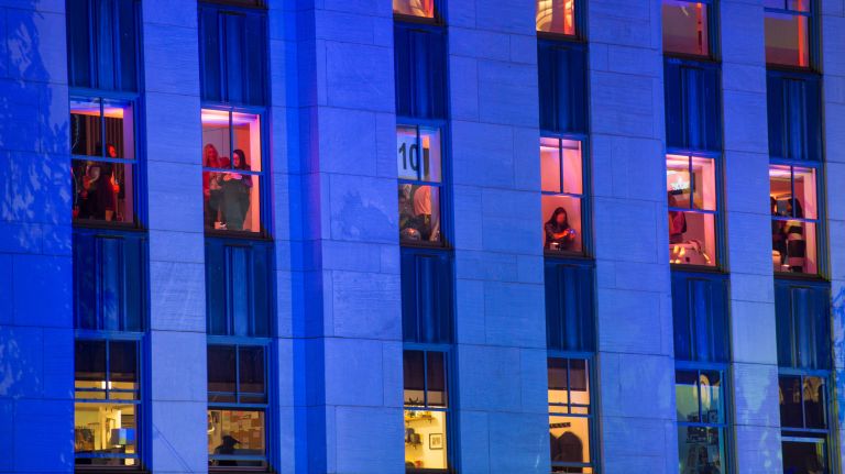 People watch from an upper floor of a building in Rockefeller Plaza as they wait to see the Christmas tree lighting on Wednesday, Nov. 29, 2017.