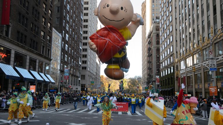 Charlie Brown flies a kite on Sixth Avenue. 