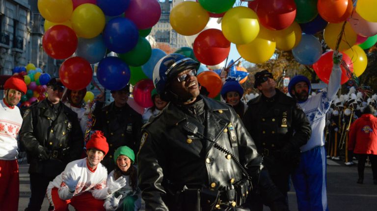 A police officer watches the parade pass by on Central Park West. 