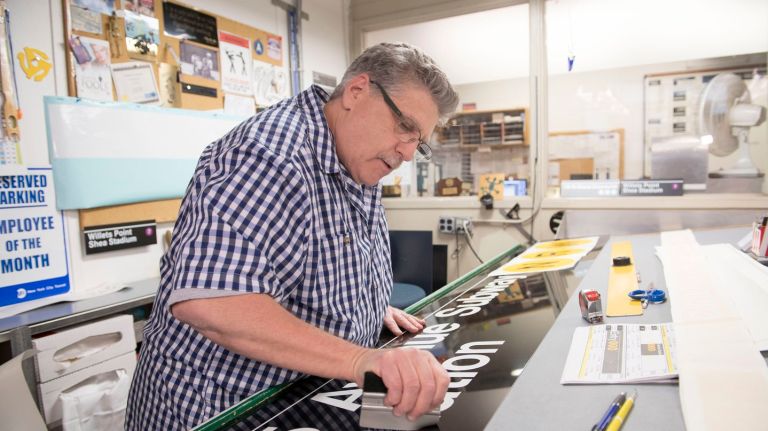 Sign fabricator Marc Lussier works on a new subway sign on Tuesday, Oct. 25, 2016.