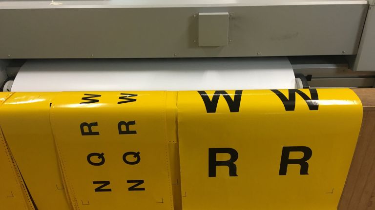 Yellow bullets for new N, Q, R and W train signs are printed on vinyl. Soon, the excess yellow vinyl will be peeled off, revealing the circle bullets. The letters will then be transferred onto their aluminum signs. 
