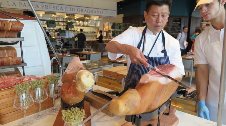 Eataly's mobile street food cart Ape (pronounced ahh-pay) is stationed in the middle of La Piazza, a restaurant area in Eataly Downtown that overlooks the World Trade Center Memorial site. Three different types of prosciutto are continuously sliced at this cart. 