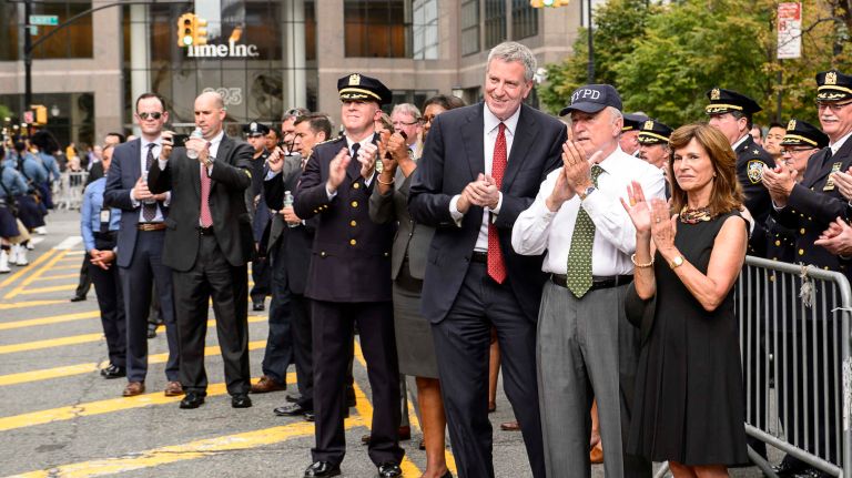 From left, Mayor Bill de Blasio, NYPD Commissioner William Bratton, and his wife Rikki Klieman view the parade on Friday, Sept. 9, 2016, to honor NYPD officers who died in the 9/11 terror attacks.
