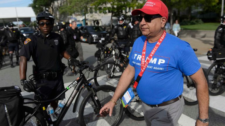 Delegates walks past police officers during and anti-Trump protestor in downtown Cleveland on the day before the start of the Republican National Convention in Cleveland, Ohio, Sunday, July 17, 2016.