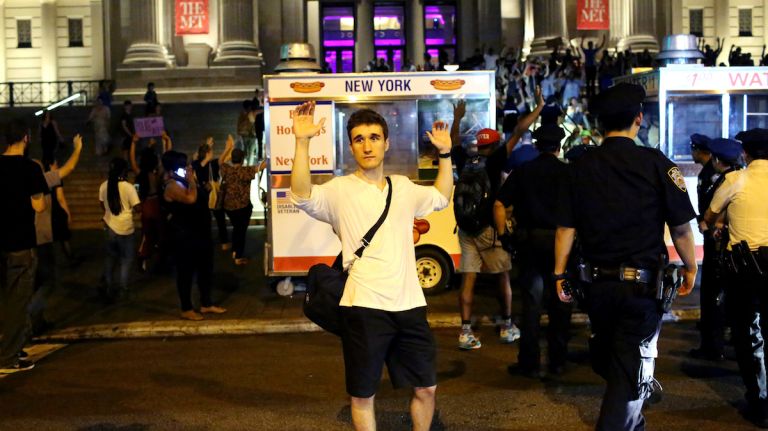 Demonstrators raise their arms during a march through Manhattan on July 7, 2016, to protest the deaths of two black men at the hands of police in Louisiana and Minnesota. 